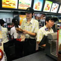 Chinese workers go about their business behind the counter at a branch of US fastood giant McDonalds in Beijing, 02 April 2007. Chinese labour...