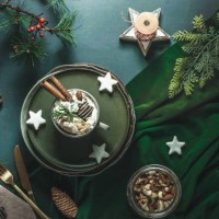 christmas background with hot chocolate with cream, biscuits, cutlery, nuts and fir green at green table - food stock pictures, royalty-free photos & images