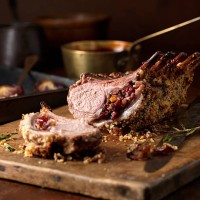 christmas dinner. lamb rack rare medium with cranberry and clementine stuffing and rosemary - food stockfoto's en -beelden