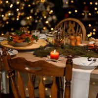 christmas lights glistening in the background behind a rustic dining table set for a christmas dinner party - home decoration stock pictures, royalty-free photos & images