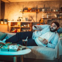 chubby guy changing channels - junk food stock pictures, royalty-free photos & images