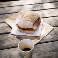 ciabatta with parma ham on wooden table outdoors - junk food stock pictures, royalty-free photos & images