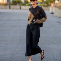 Claire Rose Cliteur wears brown black beige cashmere jumper, black wide leg pants, red heels, bag, sunglasses outside COS on September 12, 2023 in...