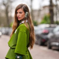 Clara Berry wears silver Lacoste earrings, dark green white oversized short sleeve shirt, dark green long sleeve shirt, outside Lacoste, during the...