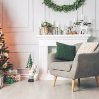 classic interior with an armchair tables, and a christmas tree with decorations on a light background of a wall with a fireplace. - home decoration stock pictures, royalty-free photos & images