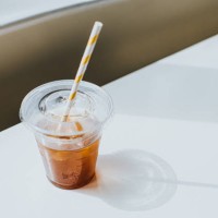 clear plastic cup half full of iced coffee, with a paper straw - junk food stock pictures, royalty-free photos & images