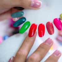 client choosing color of nail polish for manicure from palette colors. close up, only hands on white table visible. nail art, hands care, beauty concept. - nails art stock pictures, royalty-free photos & images