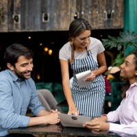 clients at a restaurant asking questions about the menu to the waitress - food stockfoto's en -beelden
