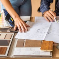 close-up of a architect discussing building blueprints with female colleague in office - home decoration stock pictures, royalty-free photos & images