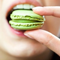 close-up of a woman eating a macaroon - junk food stock pictures, royalty-free photos & images
