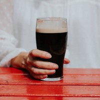 close-up of a woman holding a pint of stout - garden decoration photos et images de collection