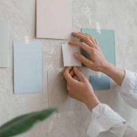 close-up of a woman taping colour paper samples to a wall - home decoration stock pictures, royalty-free photos & images