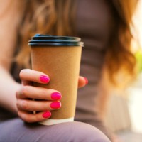 close-up of an unrecognizable young woman holding recyclable takeaway coffee cup in outdoors - junk food stock pictures, royalty-free photos & images