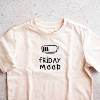 close-up of beige t-shirt with a print “friday mood” on light background, top view - fashion stock pictures, royalty-free photos & images