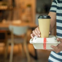 close-up of delivery man handing a slack of foam lunch box - junk food stock pictures, royalty-free photos & images