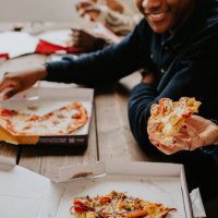 close-up of hands holding freshly delivered pizza - junk food stock-fotos und bilder