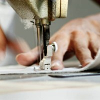 close-up of man worker sewing clothing in garment factory - fashion stock pictures, royalty-free photos & images