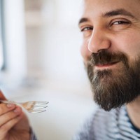 close-up of mature man indoors at home, eating cake. - food stockfoto's en -beelden