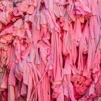 close-up of pile of scraps of pink fabric to be recycled at a textile plant. - fashion photos et images de collection