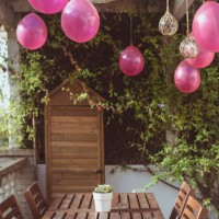 close-up of pink balloons and light decorations hanging over a garden table - garden decoration stock pictures, royalty-free photos & images