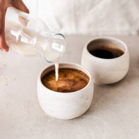 close-up of pouring oat milk into a black coffee c - coffee stock pictures, royalty-free photos & images