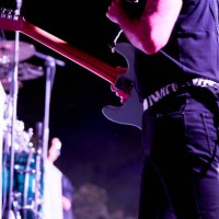 close-up of rear view of midsection of a performer standing playing his guitar in front of the blurry audience in a concert - concert stock pictures, royalty-free photos & images