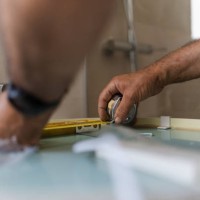 close-up of the hands of a person taking measurements for the bathroom at home. concept of works at home - home decoration stock pictures, royalty-free photos & images