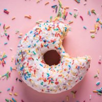 close-up of white donuts with multi colored sparks - junk food stock pictures, royalty-free photos & images