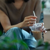 close-up of woman holding disposable cup of coffee. - junk food stock pictures, royalty-free photos & images