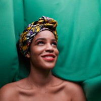close-up of woman standing against green fabric - fashion stock pictures, royalty-free photos & images