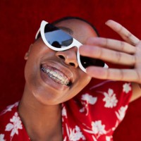 close-up of young woman gesturing against red wall - fashion stock pictures, royalty-free photos & images