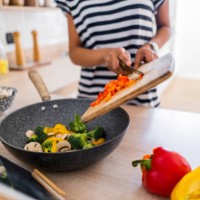 close-up of young woman with tablet cooking in kitchen at home - food stockfoto's en -beelden
