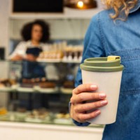 close-up on a customer buying a cup of coffee to go at a cafe - junk food stock pictures, royalty-free photos & images