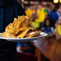 close-up on a waiter serving nachos at a sports bar - junk food stock pictures, royalty-free photos & images