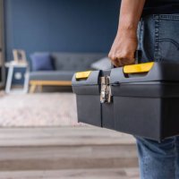 close-up on an electrician carrying a toolbox while working at a house - home decoration stockfoto's en -beelden