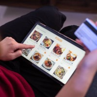 close-up view of a woman ordering food online with credit card home - junk food stock pictures, royalty-free photos & images