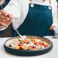 close up a chef preparing a gourmet dish. chef is decorating the plate just before the serving. - food stock pictures, royalty-free photos & images