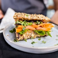 close up from fresh salmon sandwich serving from waiter - junk food stock pictures, royalty-free photos & images