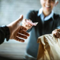 close up of a woman giving money to delivery person. - junk food stock pictures, royalty-free photos & images