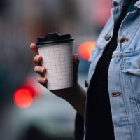 close up of an anonymous woman walking and holding a paper coffee cup - junk food stock pictures, royalty-free photos & images