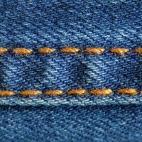 close up of golden stitches on blue denim jeans - fashion stock-fotos und bilder