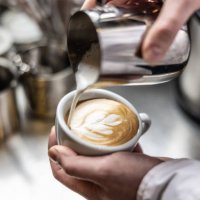 close up of hand pouring coffee latte art. barista pouring latte art photography. - coffee stock pictures, royalty-free photos & images