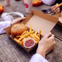close up of hands holding box with burger at street food restaurant - junk food stock pictures, royalty-free photos & images