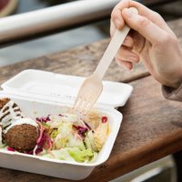 close up of healthy food in take away box, hand holding fork at urban market. - junk food stock pictures, royalty-free photos & images
