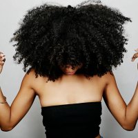 close up of mixed race woman with curly hair looking down - hairstyle fotografías e imágenes de stock