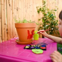 close up of terra-cotta pot with paintbrush. - garden decoration stockfoto's en -beelden