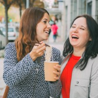 close up of two caucasian young women laughing in the street while eating asian food. food concept - junk food stock pictures, royalty-free photos & images