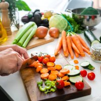 close up of woman's hands slicing fresh organic carrots on kitchen counter - food stock pictures, royalty-free photos & images