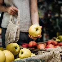 close up of young asian woman shopping for fresh organic fruits in farmer's market with a cotton mesh eco bag. environmentally friendly and zero waste concept - food stock pictures, royalty-free photos & images