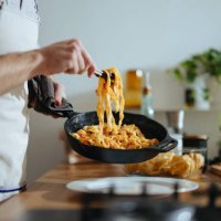 close up photo of man’s hands serving pasta with fresh vegetables - food stock pictures, royalty-free photos & images